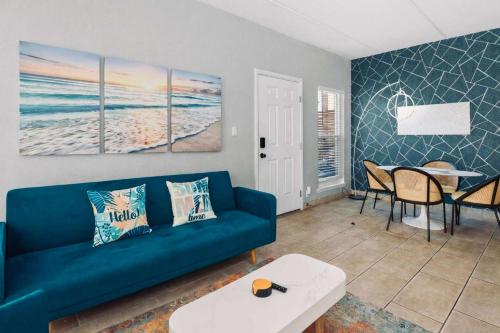 a living room with a blue couch and a table at SPI Beach Condo - Just a block away to Paradise in South Padre Island