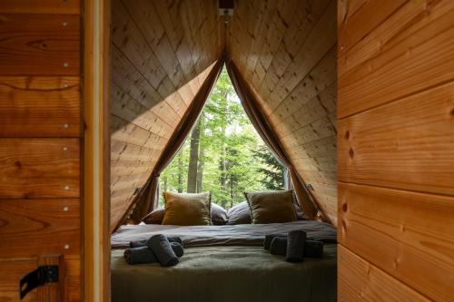 a bed in a tree house with a window at Nature's Nest - The Woods in Maribor