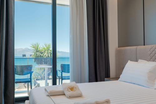 a hotel room with a bed and a balcony at Vila Era Beach in Sarandë