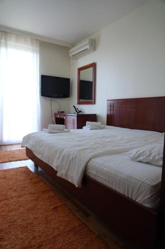 a bedroom with a large bed and a television at Konačište Compass in Kraljevo