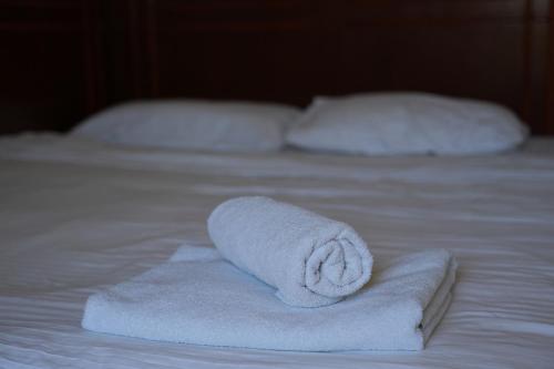 a stack of towels sitting on a bed at Konačište Compass in Kraljevo