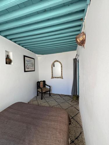 a bedroom with a bed and a blue ceiling at Dar el Marsa in Tangier