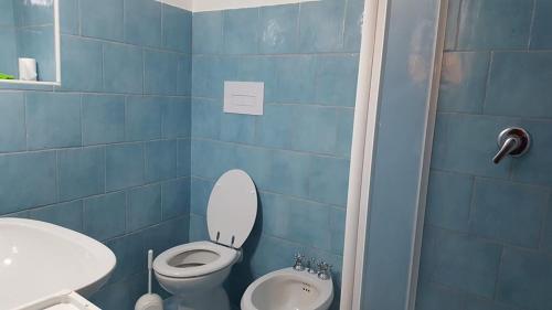 bagno piastrellato blu con servizi igienici e lavandino di Holiday Home Golfo di Orosei Cala Gonone a Cala Gonone