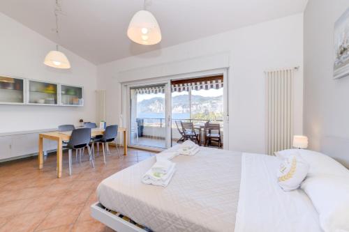 a bedroom with a large bed and a dining room at Residence Kormorano Malcesine Apt 52 in Malcesine