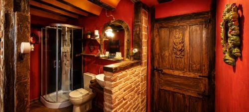 a bathroom with a toilet and a shower and a wooden door at La Casa del Ayer in Ábalos