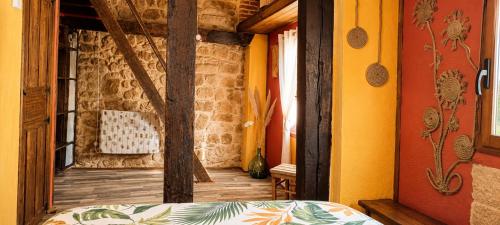 a room with a bed and a stone wall at La Casa del Ayer in Ábalos