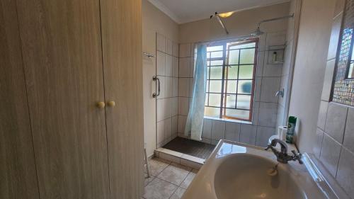 a bathroom with a tub and a shower with a window at Kings Place Montagu in Montagu