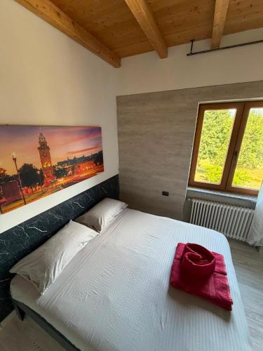 a bedroom with a white bed with a red purse on it at Agriturismo La Falesia in Bagnasco