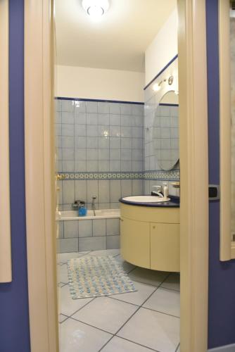 a bathroom with a sink and a tub and a mirror at appartamento Macchia in Agropoli