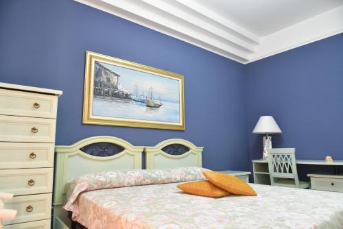a bedroom with a bed with a painting on the wall at appartamento Macchia in Agropoli