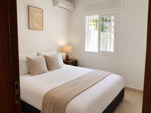 a bedroom with a white bed and a window at Beachside Garden Apartment in Marina Smir in Marina Smir