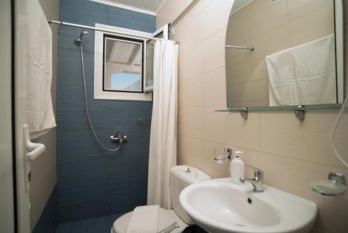 a bathroom with a sink and a toilet and a mirror at Oasis Boutique Hotel in Nydri