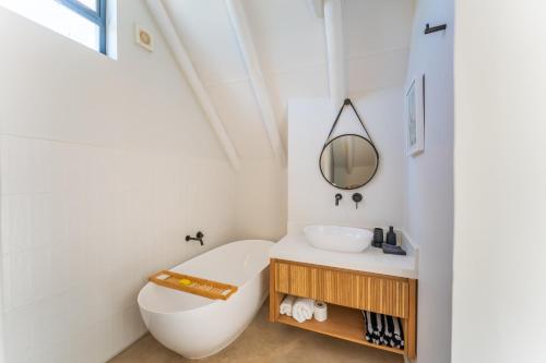 a bathroom with a tub and a toilet and a sink at Eden on Walton 1 in Sea Vista