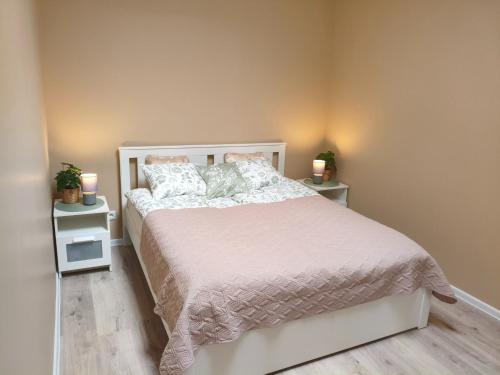 a bedroom with a white bed with two night stands at Lerihouse in Saulkrasti