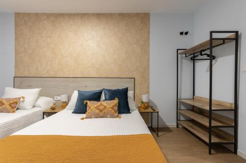 a bedroom with a bed with blue and orange pillows at Emarooms Boutique Laredo in Laredo