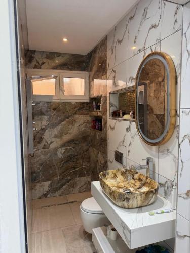 a bathroom with a sink and a toilet and a mirror at Radi in Menzel Jemil