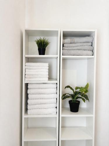 a white towel rack with towels and a plant at Kinneret Royal Penthouse in Tiberias