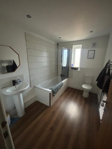 a bathroom with a tub and a sink and a toilet at Nirvana house in Deepcar