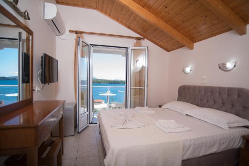 a bedroom with a bed and a view of the ocean at Oasis Boutique Hotel in Nydri
