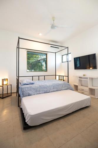 a bedroom with two beds and a flat screen tv at Private Pool, Beach Access 3BR Sleeps 6 in Chelem