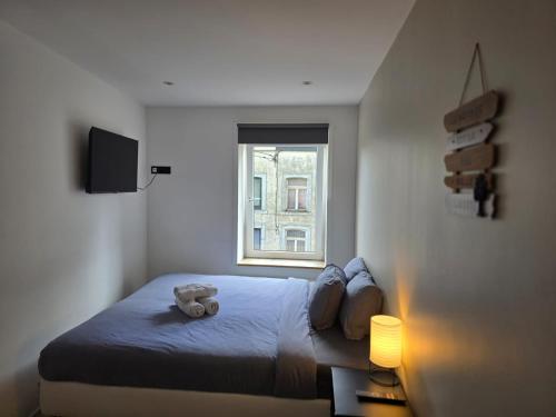 a bedroom with a bed with a teddy bear on it at Chambre 2 P à Saint Hubert in Saint-Hubert
