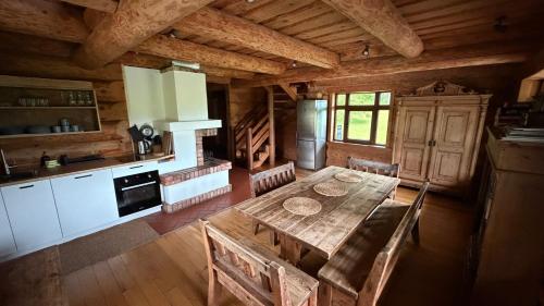 a kitchen and dining room with a table in a cabin at Vucini in Andzeļi