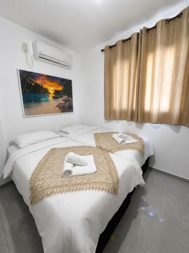 a bedroom with two beds with towels on them at Kinneret Royal Penthouse in Tiberias