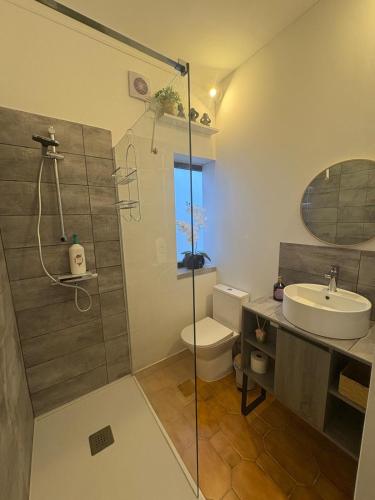 ein Badezimmer mit Dusche, Waschbecken und Toilette in der Unterkunft House Calhambeque in Meimoa