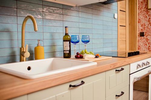 a kitchen counter with two wine glasses and a sink at Dom pod Niebem in Lucimia