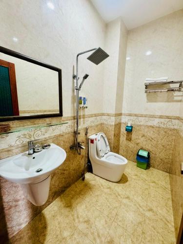 a bathroom with a sink and a toilet and a mirror at Minh Thư Phú Mỹ Hotel in Phú Mỹ
