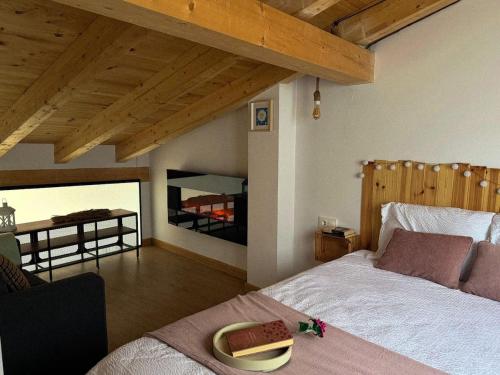 a bedroom with two beds and a wooden ceiling at El Rincón de María II in Torrecilla en Cameros