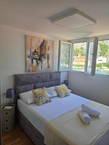 a bedroom with two beds and a painting on the wall at Apartment Maris in Omiš