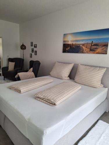 a white bed with two pillows on top of it at Ferienwohnung III in Eisenhüttenstadt
