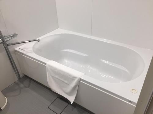 a white bath tub with a white towel on it at Amakusa Santacoming Hotel in Amakusa