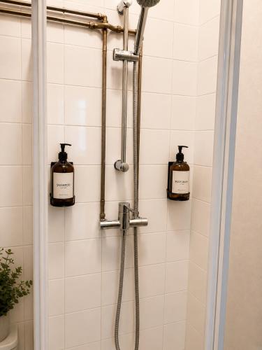 a shower with two bottles of soap in a bathroom at Espaço-Zero Downtown Porto in Porto