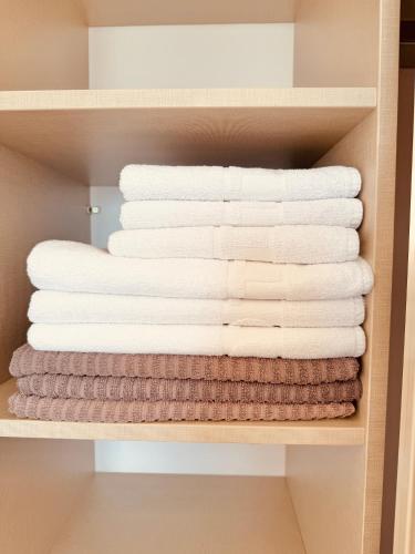 a stack of folded towels in a closet at Skyline View Apt & Sea View Terrace in Budva