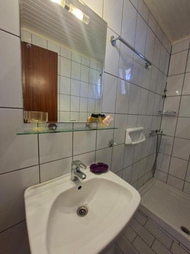 a white bathroom with a sink and a shower at Pension Assos in Koinyra