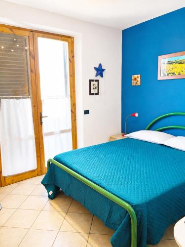 a blue bedroom with a bed with a blue wall at Casa Guia a Marina di Cecina con parcheggio privato in Marina di Cecina