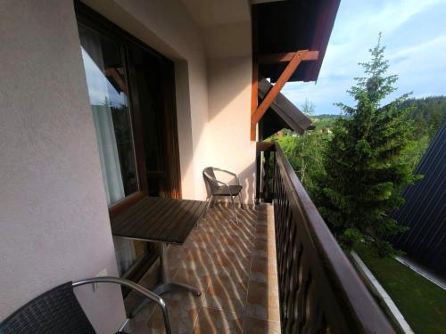 a balcony with a wooden bench and a chair on it at Apartmani Jasika Zlatar in Nova Varoš