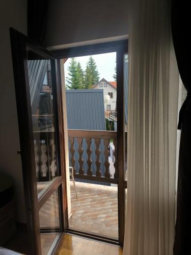 an open glass door with a view of a balcony at Apartmani Jasika Zlatar in Nova Varoš
