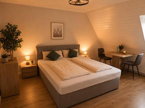 a bedroom with a bed and two chairs and a desk at Hotel NeckarOase in Lauffen am Neckar