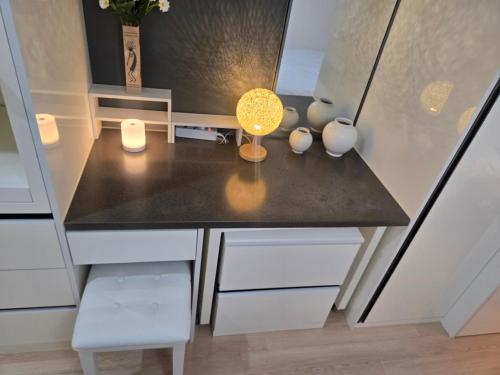 a kitchen with a black counter top and white cabinets at 여유스테이 2호점 in Suwon