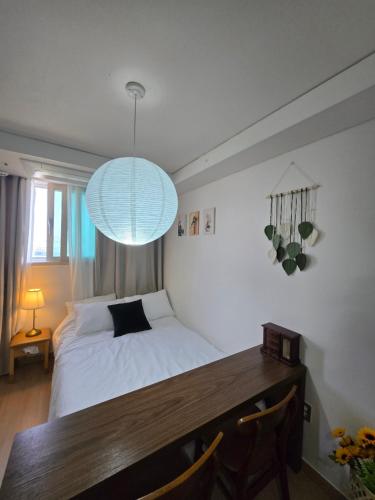 a bedroom with a bed and a table and a light at 여유스테이 2호점 in Suwon