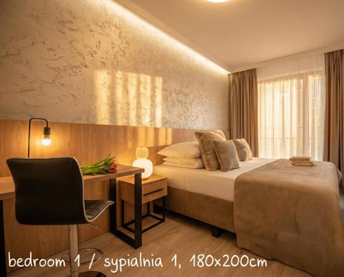a bedroom with a bed and a desk with a chair at City Lights Apartments in Krakow