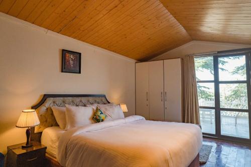 a bedroom with a large white bed and a window at Holiday In Homestay in Shimla