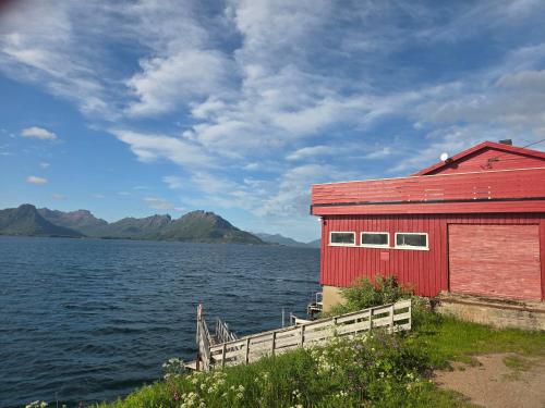 a red building next to a large body of water at Grønningbrygga in Grønning