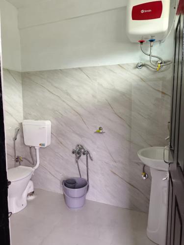a small bathroom with a toilet and a sink at Heijo's Travellers Nest in Jarain