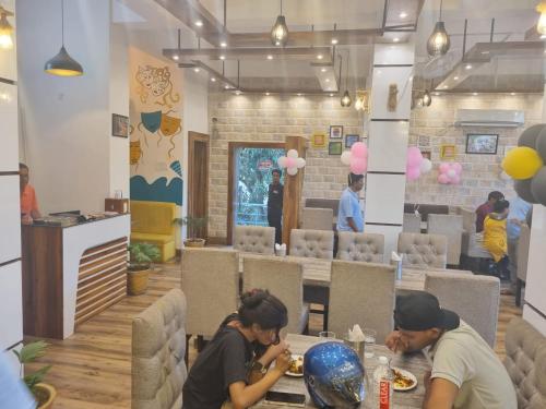 two people sitting at a table in a restaurant at Laxmi Kantam Vatika in Patna