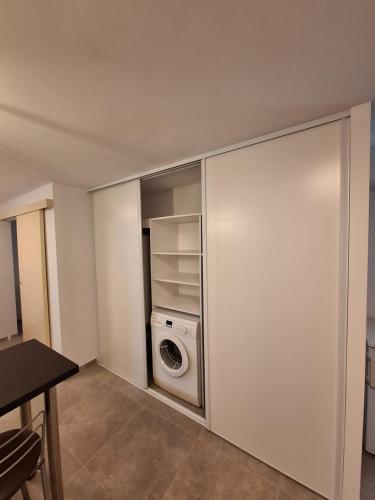 a laundry room with a washer and a washing machine at La Campanule in Saint-Cyr-en-Pail
