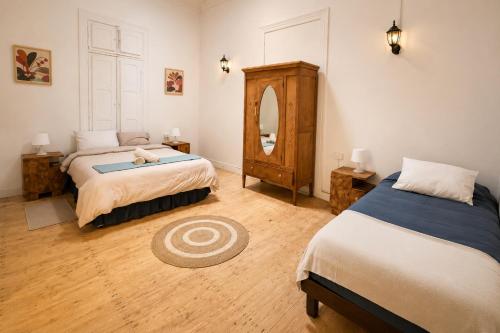 a bedroom with two beds and a mirror at Silvestre Hostel in Pichilemu
